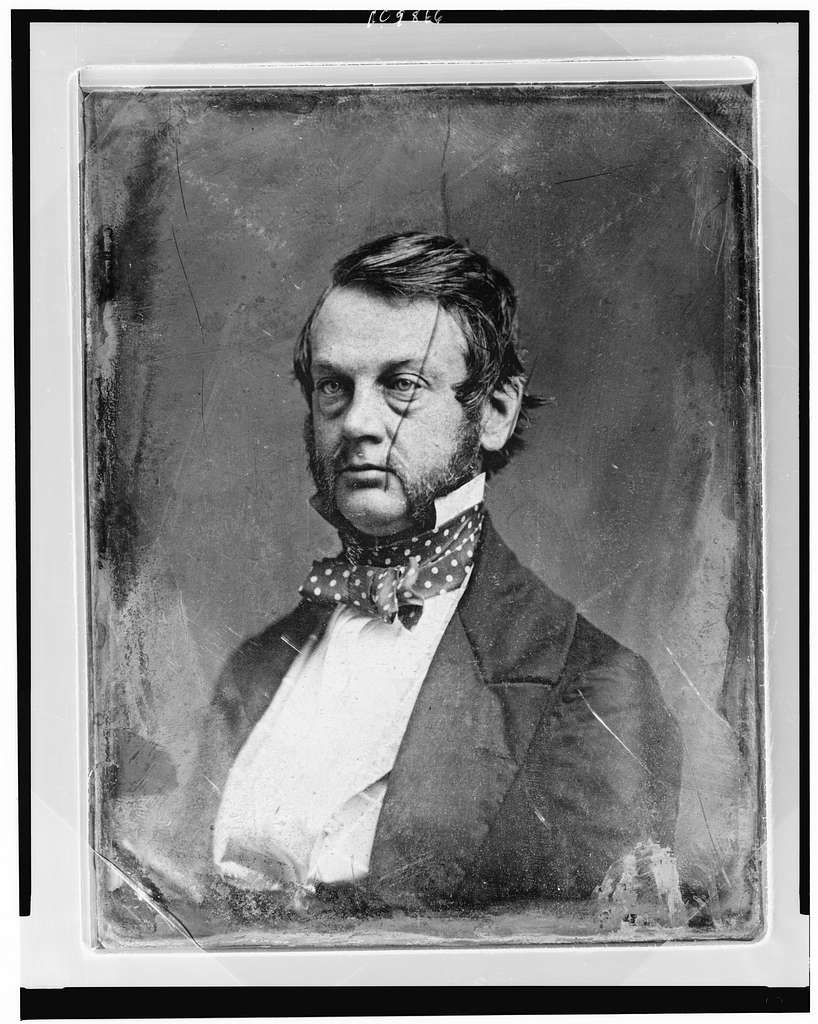 McRaven Mansion. A black and white photo of a man with mutton chops. Dressed in the style of the late 1800s.